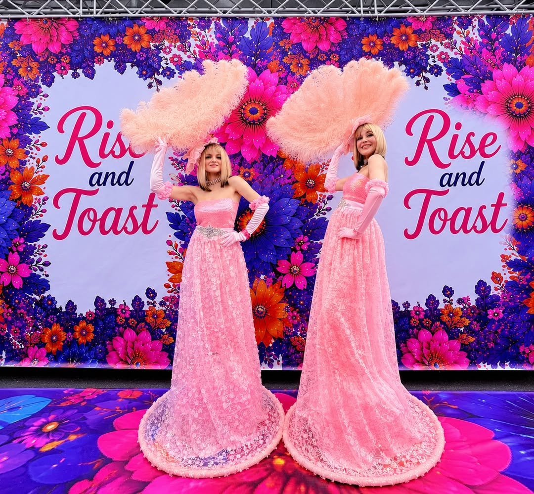Neon Circus showgirls in pink gowns with feather fans